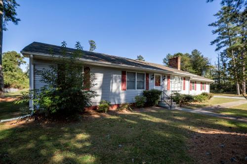 a white house with a tree in the yard at Happy Pines in Chincoteague
