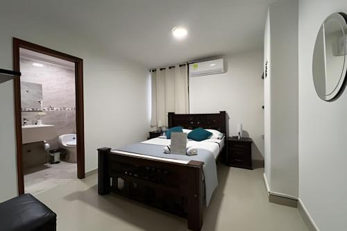 a bedroom with a bed and a bathroom with a mirror at Soberana del Mar by Colproperty Management in Santa Marta