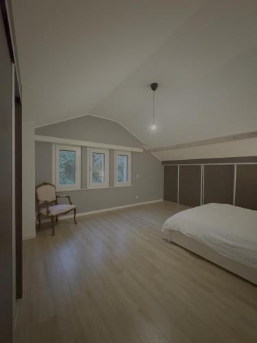 a bedroom with a bed and a chair in it at Dressing vibe in Ettelbruck