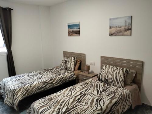 two beds sitting next to each other in a room at Alojamientos Harizan in Agaete