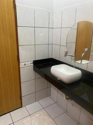 a bathroom with a sink and a mirror on a counter at Casa com piscina in Imperatriz