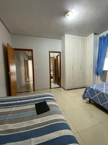 a bedroom with a bed with a black book on it at Casa com piscina in Imperatriz