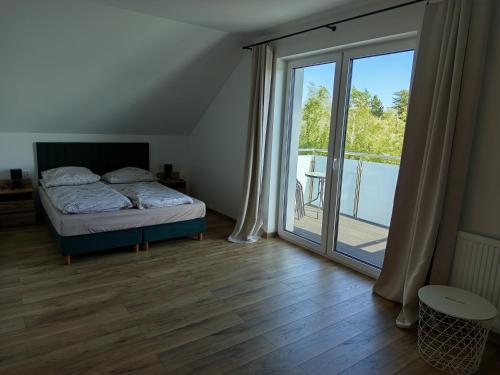 a bedroom with a bed and a sliding glass door at u Harrego in Dębki