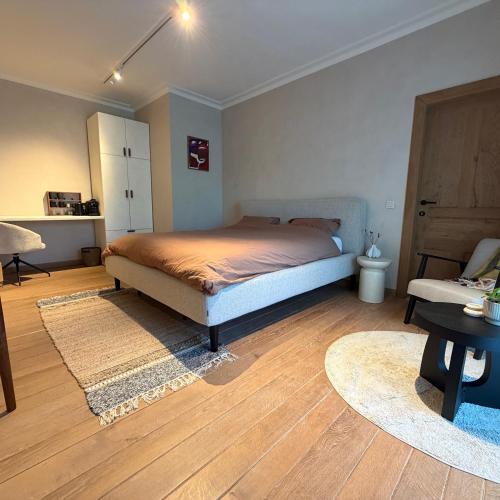 a bedroom with a bed and a wooden floor at La Petite Suite - Unique Guesthouse in Schilde