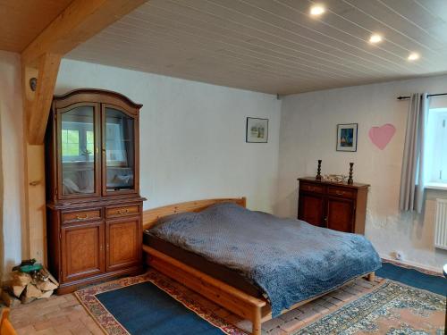 ein Schlafzimmer mit einem Bett, einem Holzschrank und einem Fenster in der Unterkunft Sonnenberghof in Glashütte