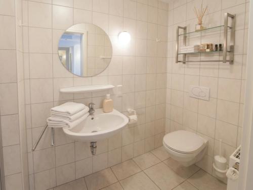 a white bathroom with a sink and a toilet at Apartment Leefke im Dangaster Nest in Varel