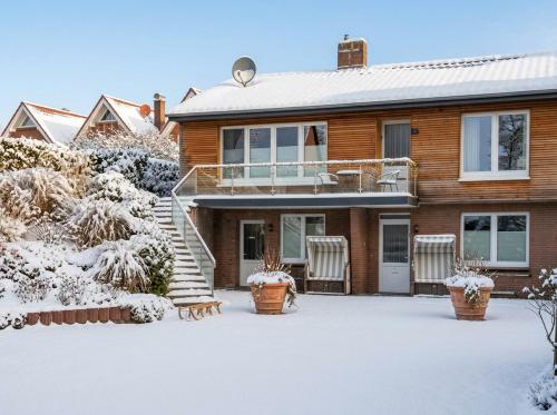 a house with snow on the ground in front of it at Apartment Leefke im Dangaster Nest in Varel