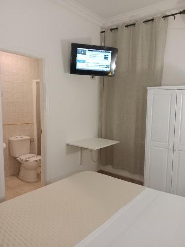 a bedroom with a bed and a tv on the wall at Hostal Alcarayón Pilas in Pilas