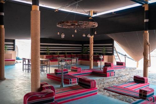 a room with red chairs and tables in a building at مخيم سياحي in Disah