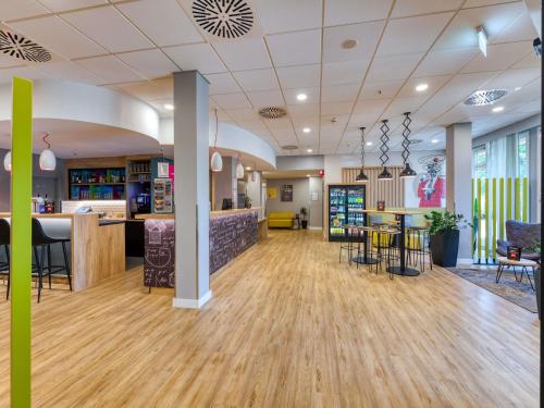 a large lobby with a bar and a restaurant at ibis Hotel Frankfurt Messe West in Frankfurt