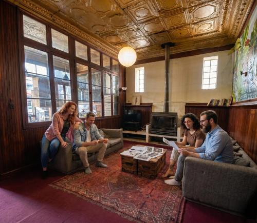 a group of people sitting in a living room at Escarabajo Hostel in Valparaíso