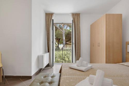 a bedroom with a bed and a sliding glass door at Borgo al Mare in Marina di Bibbona