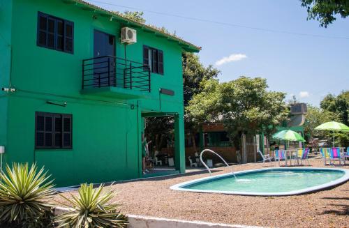 a green building with a swimming pool in front of it at Hotel Popular in Pântano Grande