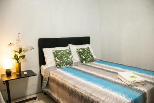a small bedroom with a bed with a vase of flowers at Hotel Popular in Pântano Grande