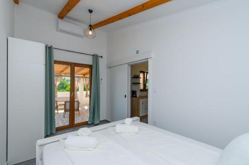 a white room with a table with two towels at House Guesthouse Stipe in Lopar