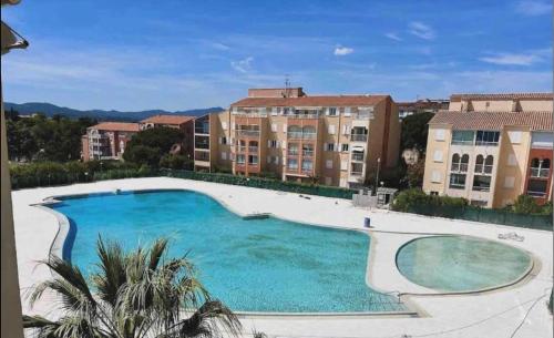 a large swimming pool with buildings in the background at Magnifique appartement à Fréjus in Fréjus