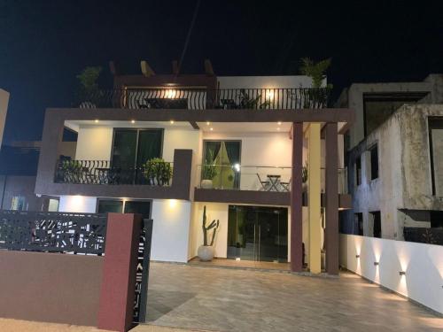 a large white building with a balcony at night at Ridge Condos Hotel - Phase Three in Kumasi