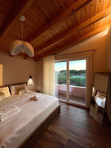 a bedroom with a large bed and a large window at Sunset Aura Riverside Villa & Pool in Draç