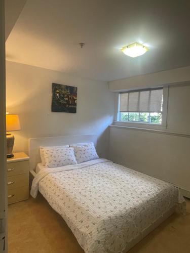 a bedroom with a bed and a window at Manor guesthouse in Vancouver