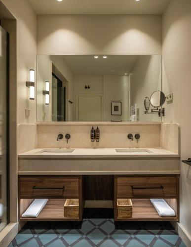 a large bathroom with two sinks and a large mirror at POSTCODE Chueca in Madrid
