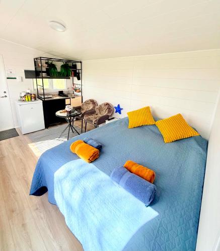 a bedroom with a blue bed with pillows on it at Baksas Luxury Campers in Selfoss