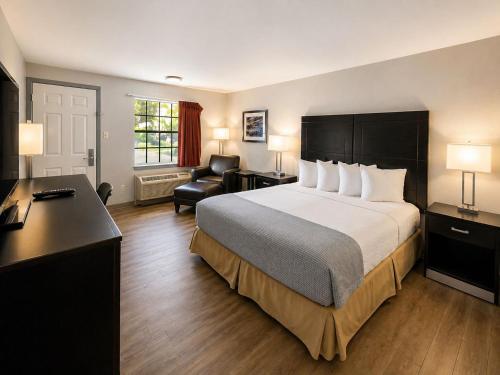 a hotel room with a large bed and a desk at Silver Queen Inn in Kingman