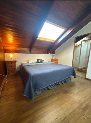 a bedroom with a bed with a blue blanket and a window at ROSETTA Café & Camas in La Serena
