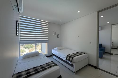 a bedroom with two beds and a window at Ocean Club by Colproperty Management in Playa Bello Horizonte