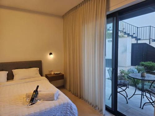 ein Schlafzimmer mit Bett und ein Balkon mit Tisch in der Unterkunft מנות בטבע in Manot