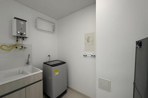 a white bathroom with a sink and a trash can at Ocean Club by Colproperty Management in Playa Bello Horizonte