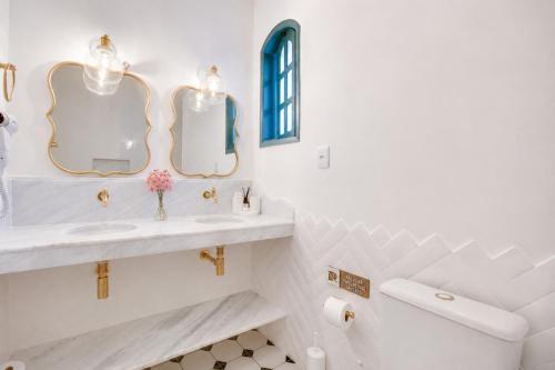 a bathroom with two sinks and a mirror at Elsi Pousada in Búzios