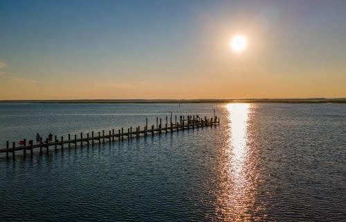 a dock in the water with the sun setting at Paradise in Chincoteague