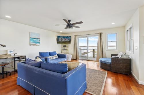 a living room with a blue couch and a ceiling fan at Paradise in Chincoteague