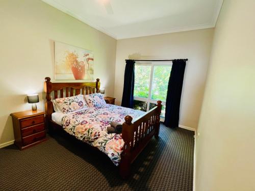 a bedroom with a bed and a window at Treetops Escape Albury in Albury