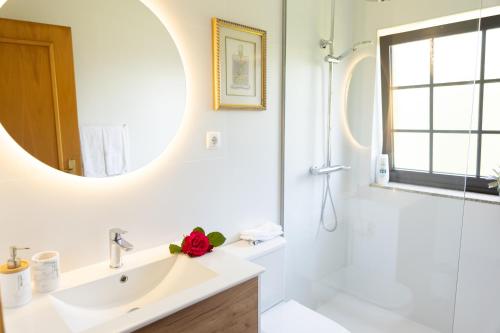 a white bathroom with a sink and a mirror at Suite em Viana do Castelo in Viana do Castelo