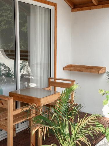 a table and chairs on a balcony with plants at Boli Dhigurah in Dhigurah