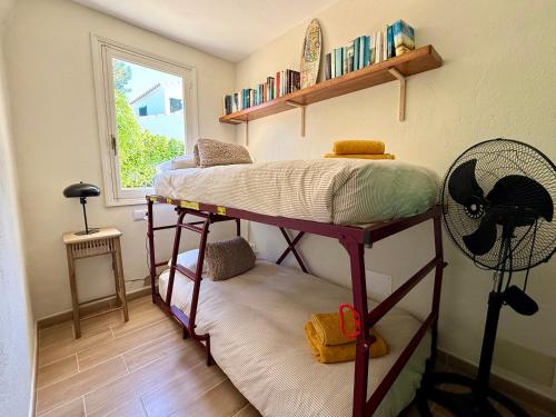 a room with two bunk beds and a fan at Casa Maya by GMHouse Menorca in Cala Blanca