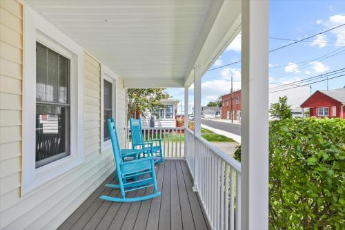 two blue chairs sitting on the porch of a house at Precious Time in Chincoteague