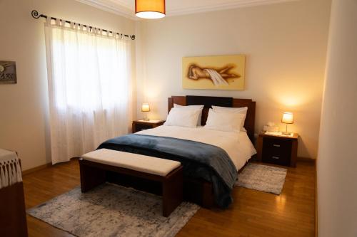 a bedroom with a large bed and a window at Suite em Viana do Castelo in Viana do Castelo