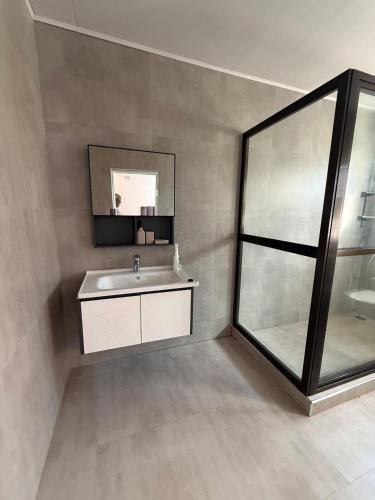 a bathroom with a sink and a mirror at Central place in Lusaka