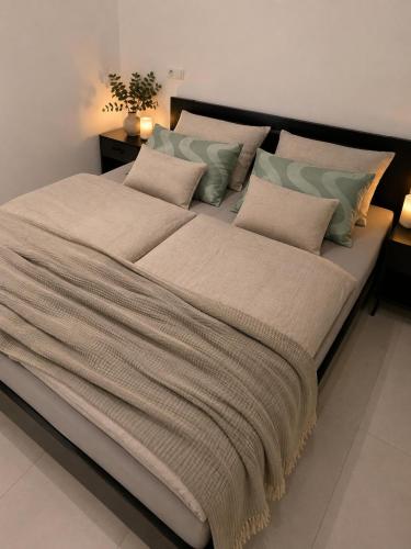 a large bed with a blanket and pillows on it at La Piccola Italia in Deggingen