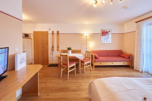 a living room with a red couch and a table at Gästehaus Gruber in Piding