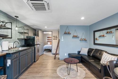 a living room with a black couch and a kitchen at Modern Pet-Friendly Cottage - Graystone Retreat in Prescott