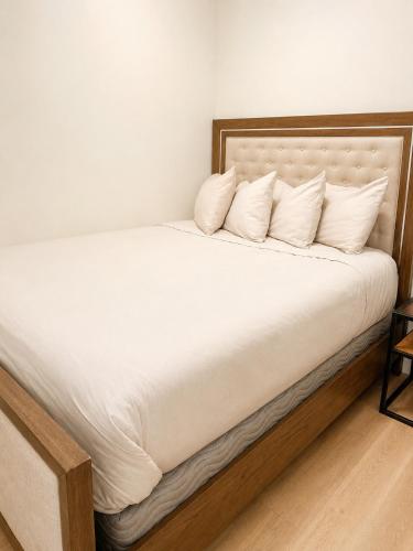 a large bed with white sheets and pillows at Lovely Brand New Suite in Sidney