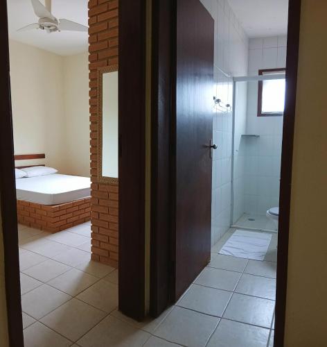 a bathroom with a shower and a bathroom with a bed at Refugio e Fortaleza in Ubatuba