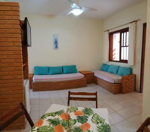 a living room with two benches and a table at Refugio e Fortaleza in Ubatuba