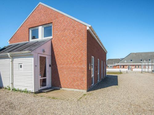 a red brick building with a white garage at 6 person holiday home in Rømø-By Traum in Sønderby
