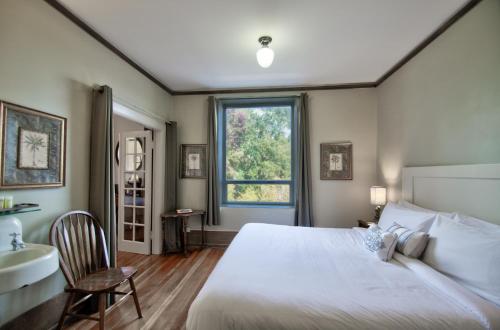 a bedroom with a bed and a sink and a window at The Peak at Centralia Square - Self Check-In Hotel in Centralia