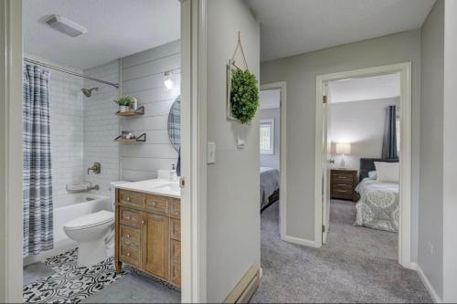 a bathroom with a sink and a toilet and a bed at Central White Mountains Retreat in Bartlett