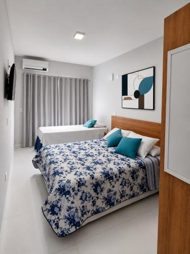 a bedroom with two beds with blue and white sheets at Paúba Beach Hotel in Pauba